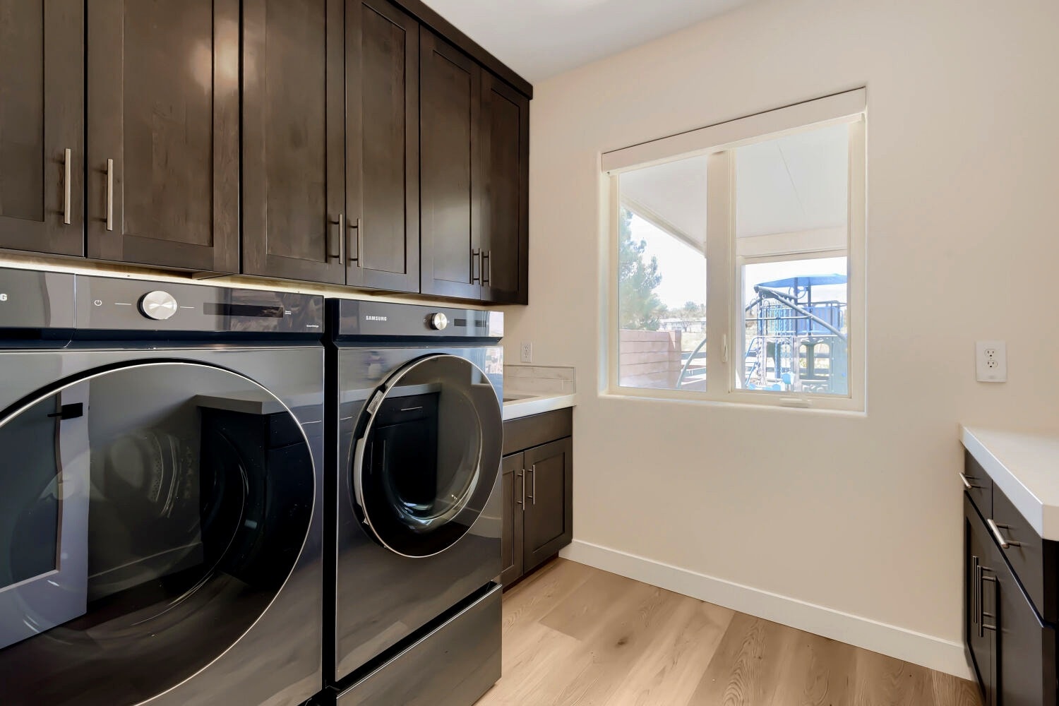 Modern laundry room with dark cabinetry